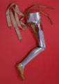 Photo of steel leg with leather hip fixings against a red background